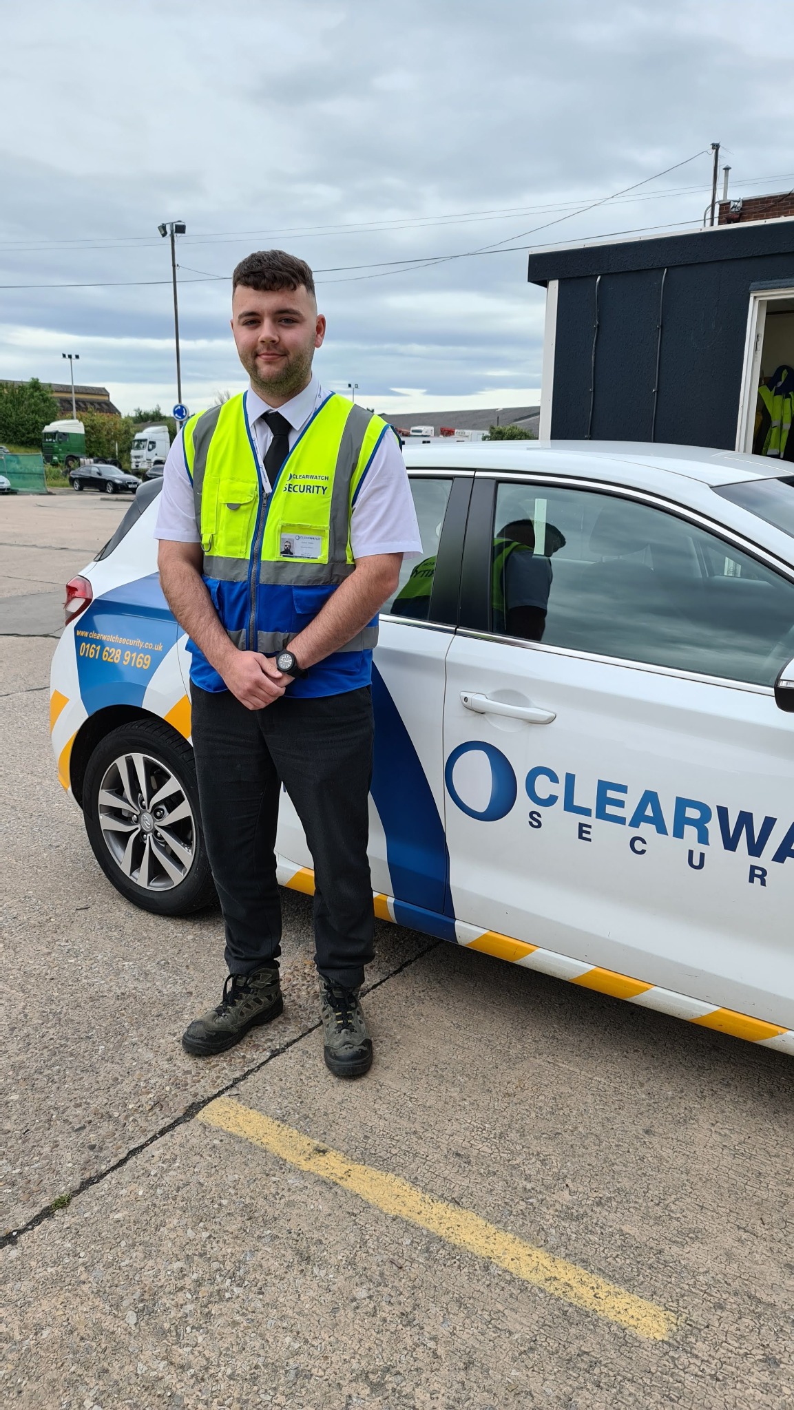 Clear Watch Security officer beside a branded response vehicle